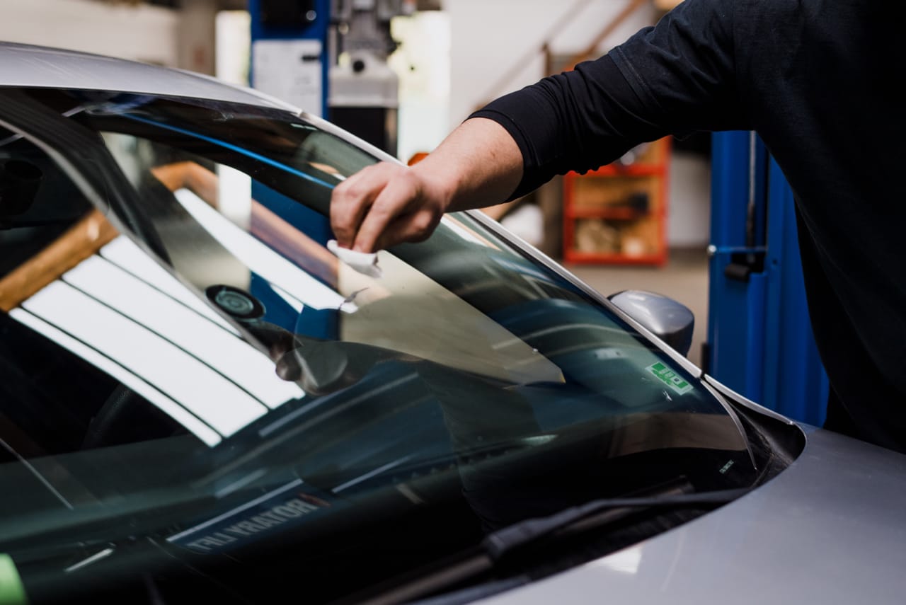 man refilling motor oil on car engine bay